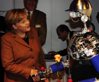 Illustration for article titled Why Is Angela Merkel Always Palling Around With Robots?